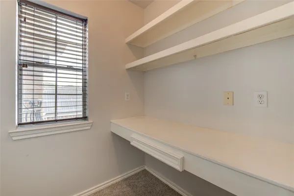 a view of a room that has a window and a white door