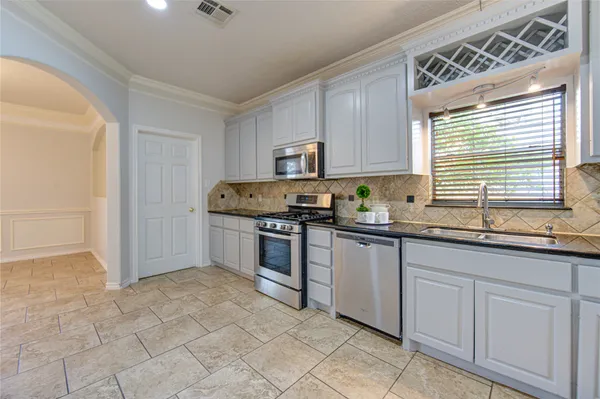 a kitchen with granite countertop a sink and a stove