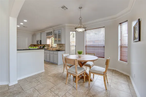 a kitchen with granite countertop stainless steel appliances a table and chairs in it