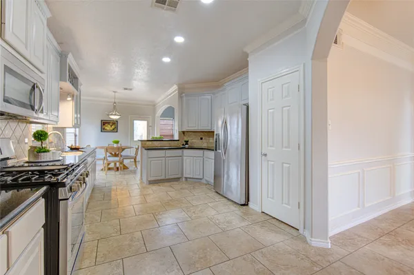 a view of a kitchen with cabinets and stainless steel appliances