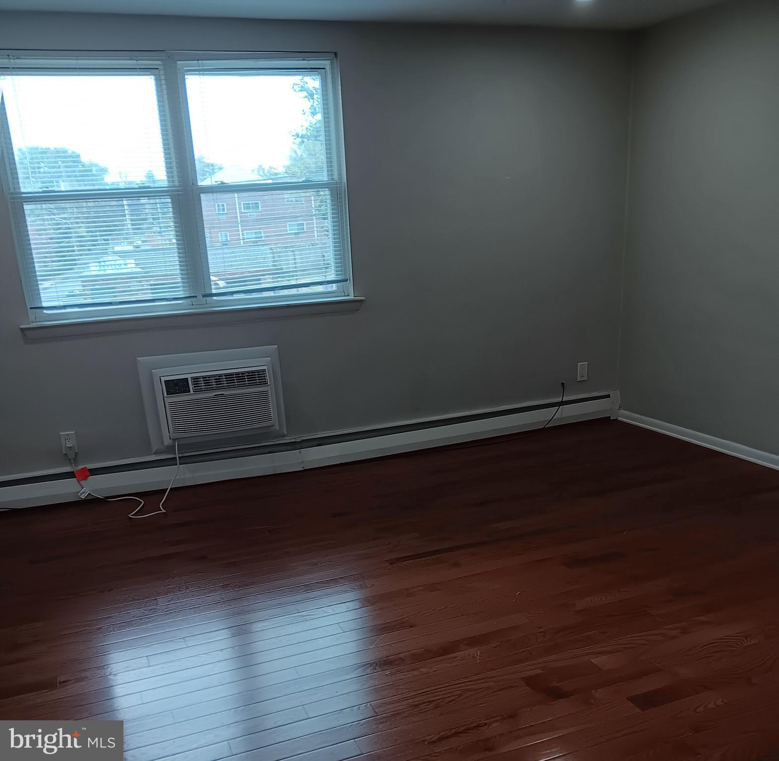 153 Burmont Road, Unit B Drexel Hill, PA 19026 - Photo 2 of 19 an empty room with wooden floor and windows