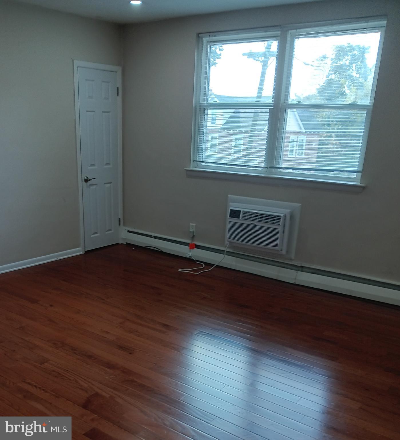 153 Burmont Road, Unit B Drexel Hill, PA 19026 - Photo 3 of 19 an empty room with wooden floor and windows