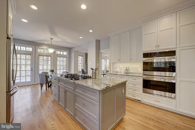 a kitchen with stainless steel appliances granite countertop a stove and a wooden floors
