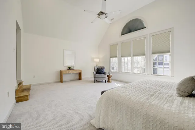 a spacious bathroom with a tub shower and windows