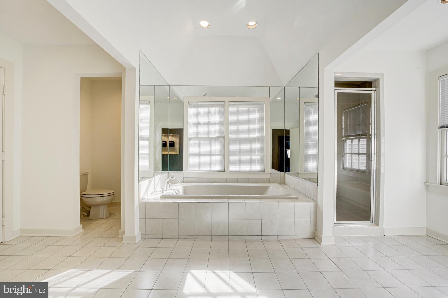 10505 Democracy Lane Potomac, MD 20854 - Photo 27 of 47 a spacious bathroom with a tub shower and windows