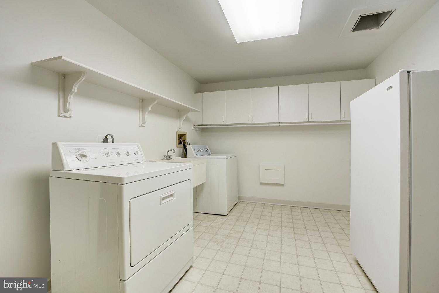 10505 Democracy Lane Potomac, MD 20854 - Photo 42 of 47 a utility room with cabinets washer and dryer