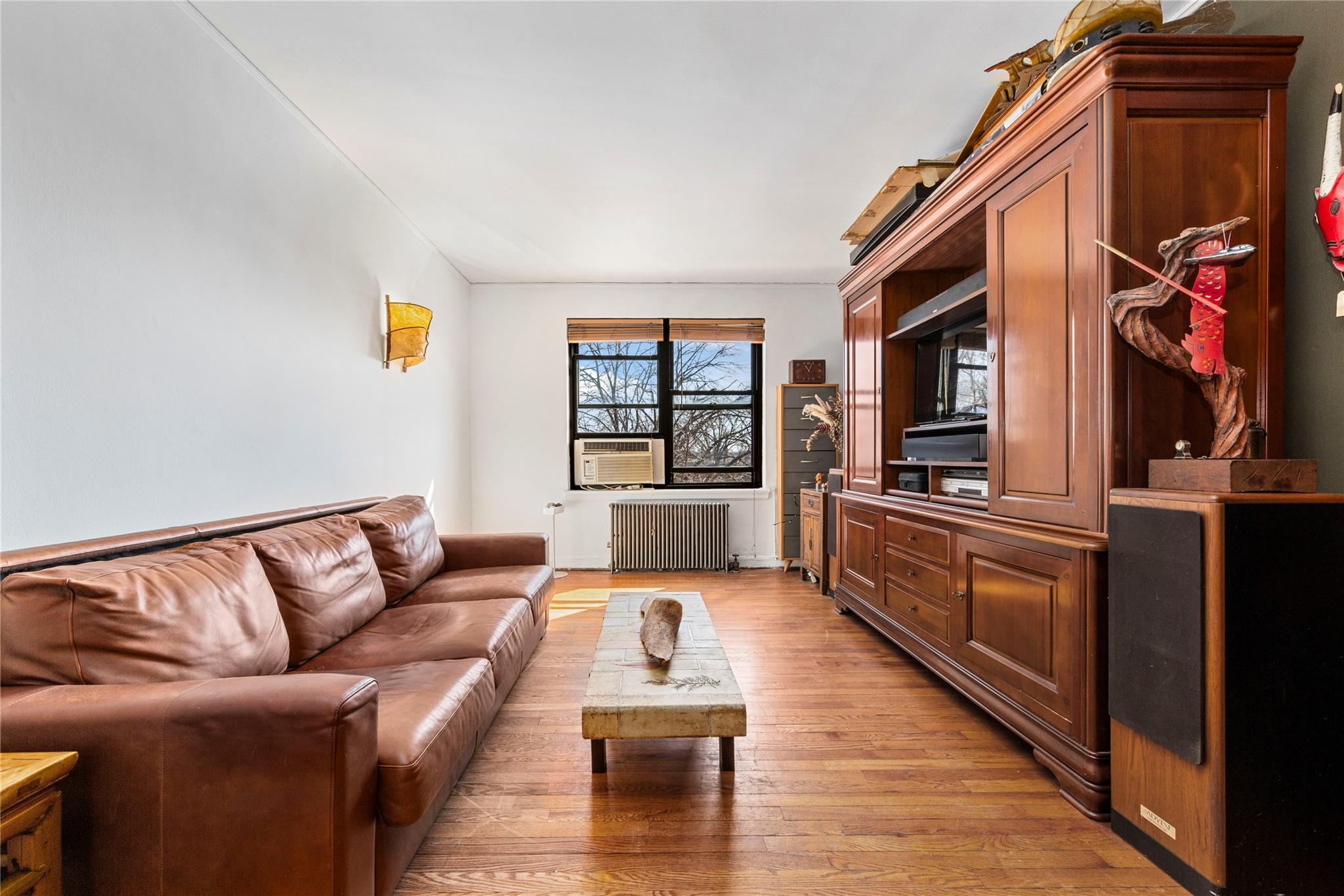 22-20 78th Street, Unit A3 Queens, NY 11370 - Photo 2 of 10 Living room with cooling unit, light wood-style flooring, and radiator