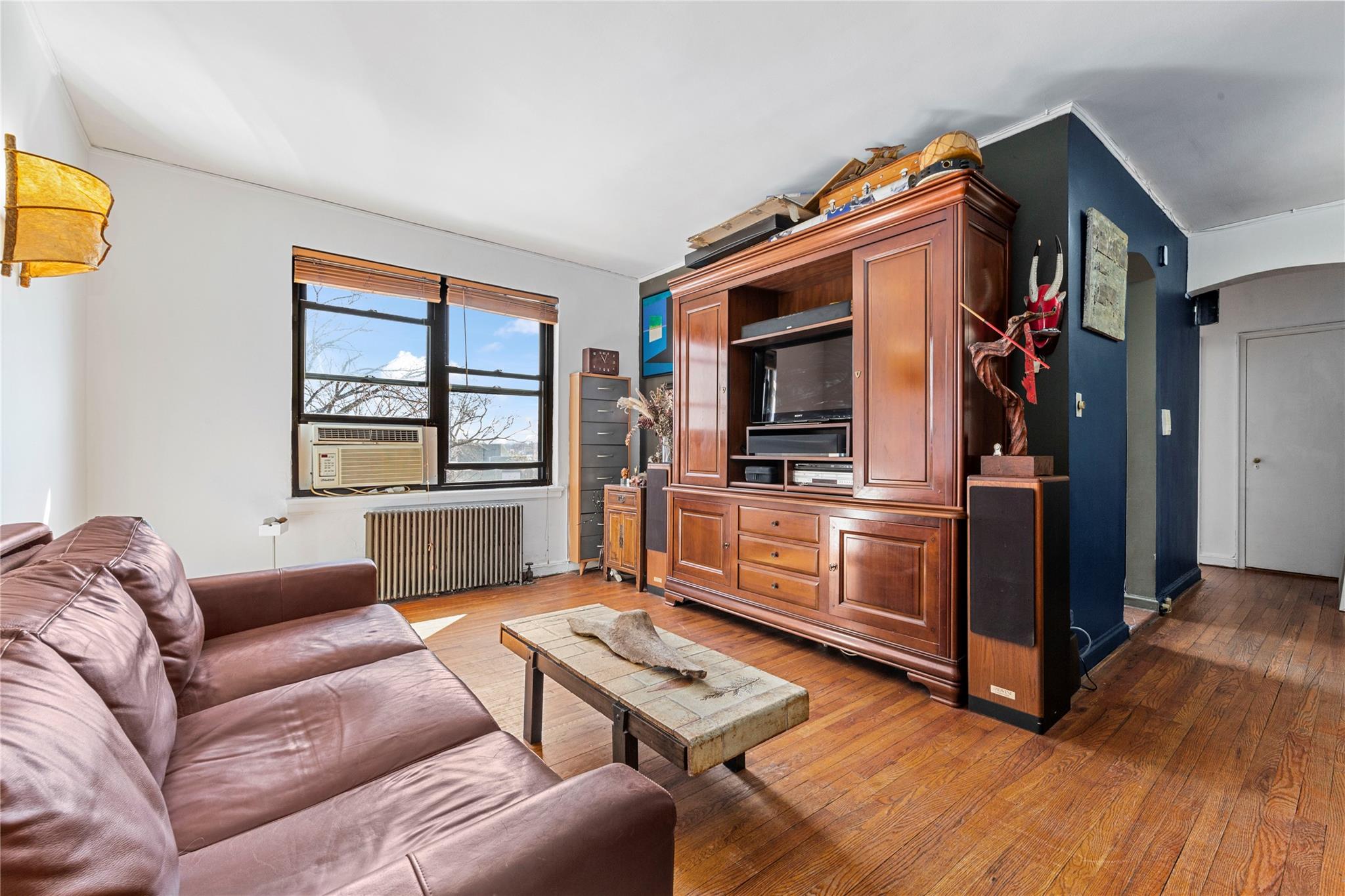 22-20 78th Street, Unit A3 Queens, NY 11370 - Photo 3 of 10 Living room featuring cooling unit, radiator, and hardwood / wood-style flooring