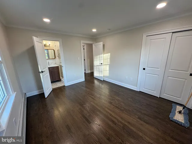 an empty room with wooden floor and mirror