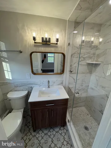 a bathroom with a sink toilet a mirror and shower