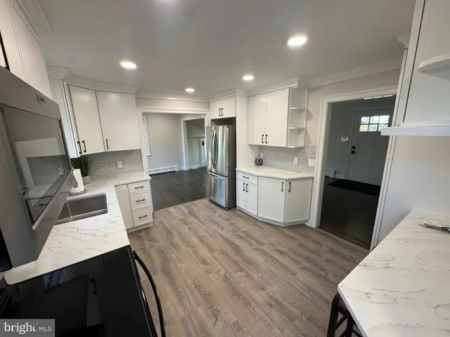 a kitchen with stainless steel appliances a refrigerator a sink a stove a microwave and cabinets