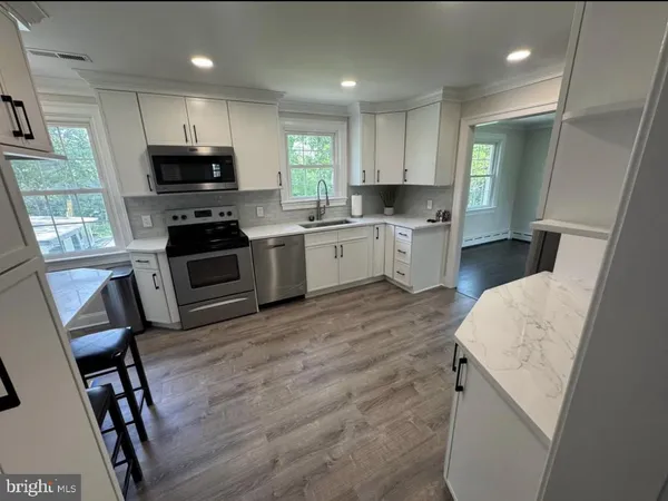 a kitchen with stove cabinets and wooden floor