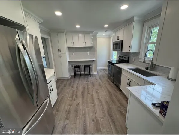 a kitchen with stainless steel appliances a refrigerator sink and stove