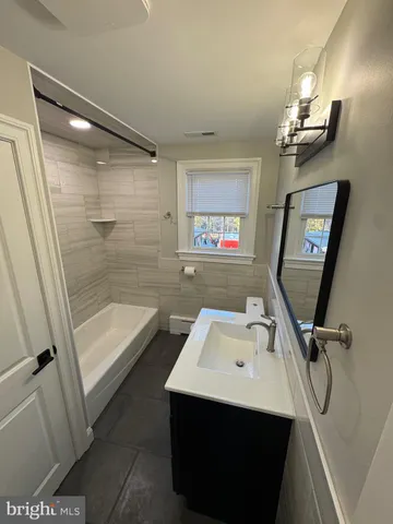 a bathroom with a sink a tub and a mirror