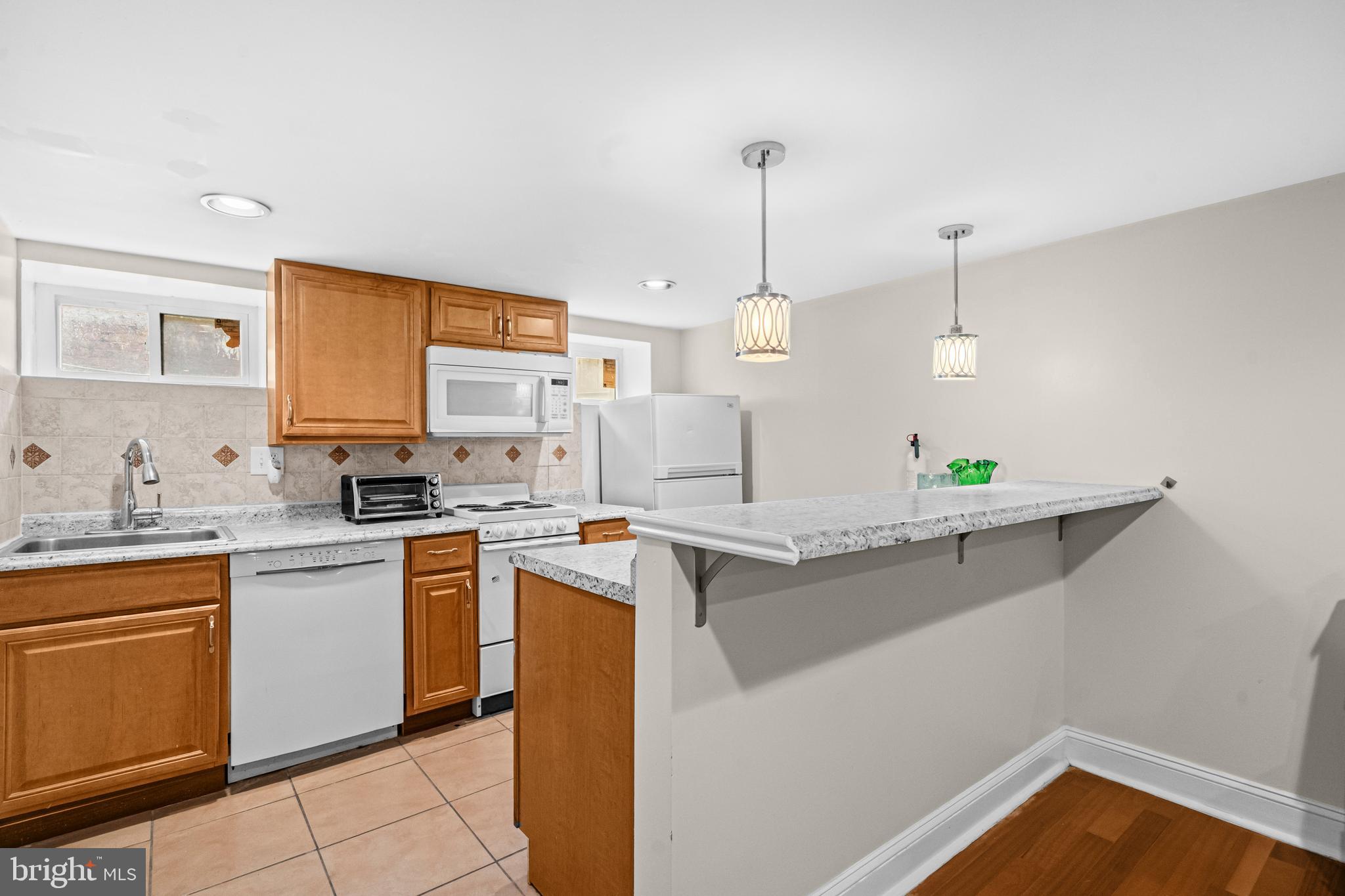 504 Kenyon Street Northwest Washington, DC 20010 - Photo 23 of 38 a kitchen with a sink a stove a refrigerator and cabinets