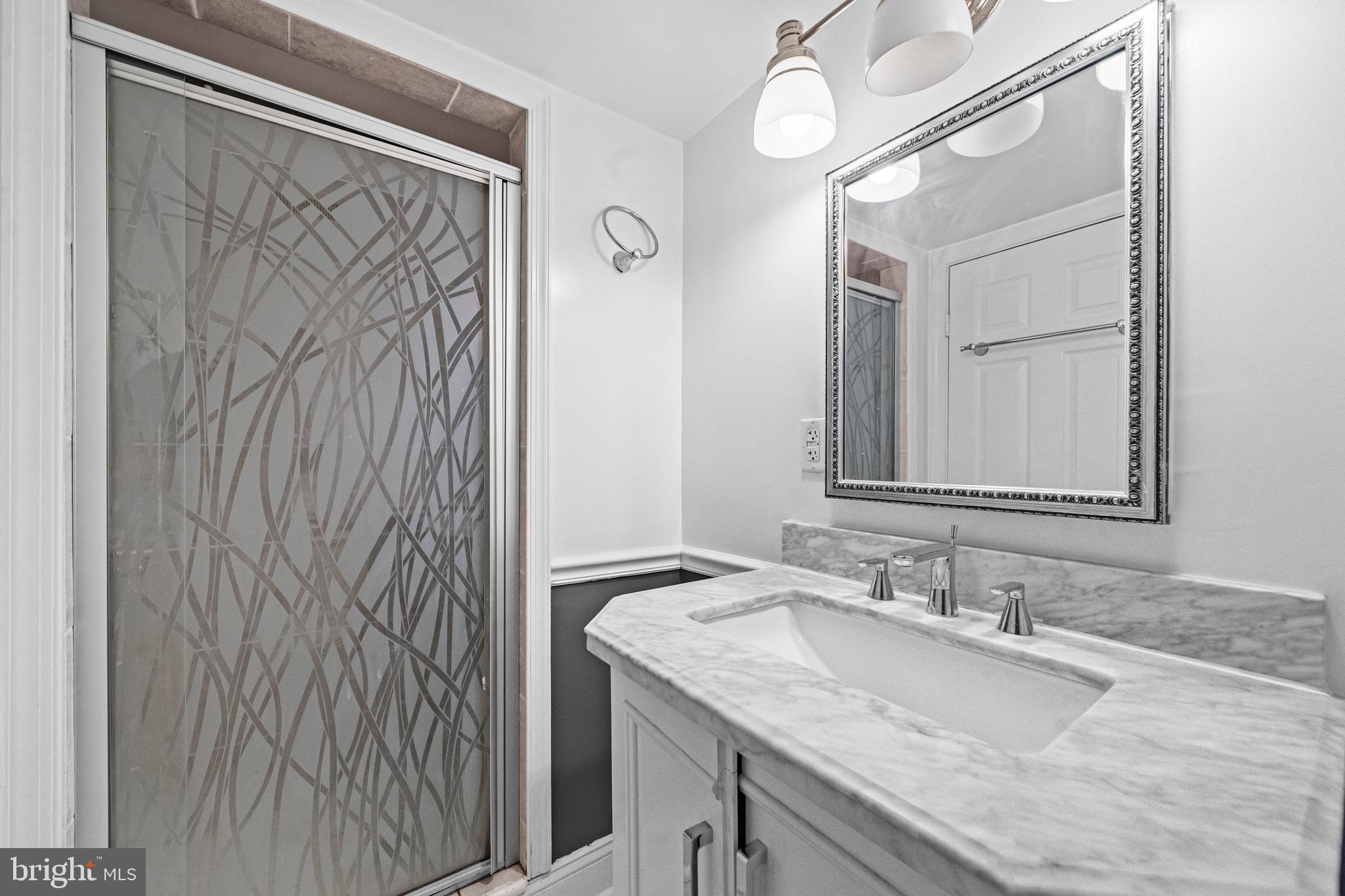 504 Kenyon Street Northwest Washington, DC 20010 - Photo 30 of 38 a bathroom with a granite countertop sink and a mirror