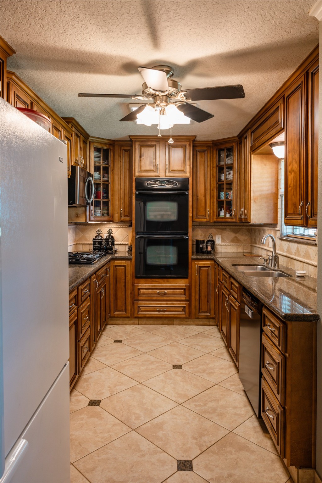 318 Peach Point Road Jones Creek, TX 77541 - Photo 11 of 27 a kitchen with stainless steel appliances granite countertop a stove and a refrigerator