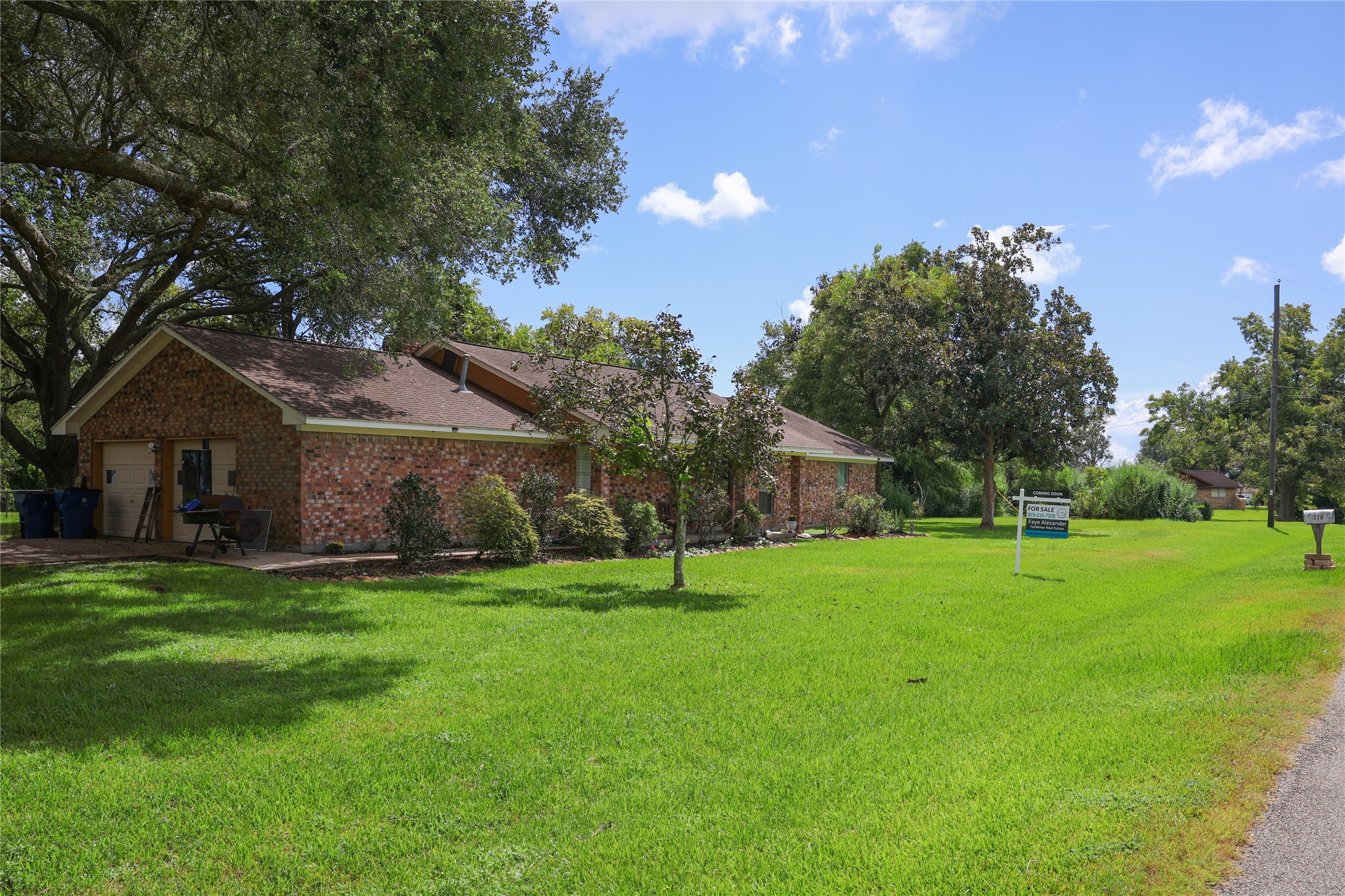318 Peach Point Road Jones Creek, TX 77541 - Photo 3 of 27 a house with a big yard and large trees