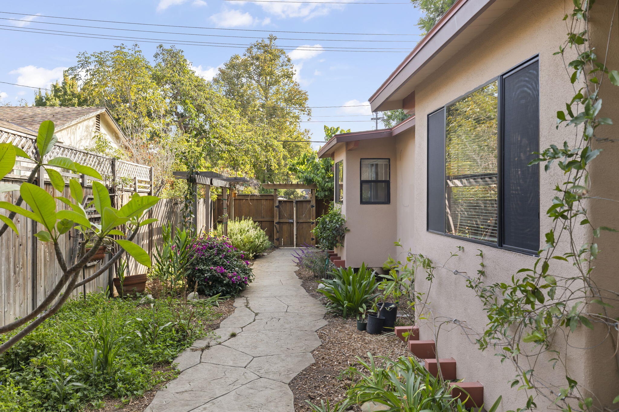 5130 Cathedral Oaks Road Santa Barbara, CA 93111 - Photo 3 of 68 a front view of a house with a lot of flower plants