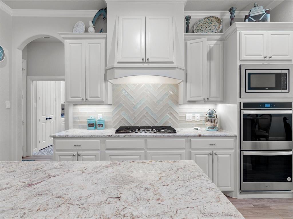 209 Rio Rancho Drive Decatur, TX 76234 - Photo 14 of 34 a kitchen with granite countertop white cabinets and stainless steel appliances