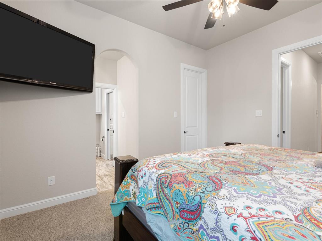 209 Rio Rancho Drive Decatur, TX 76234 - Photo 23 of 34 a bedroom with a bed and a chandelier