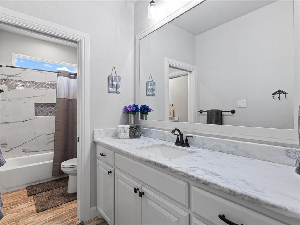 209 Rio Rancho Drive Decatur, TX 76234 - Photo 24 of 34 a bathroom with a granite countertop toilet sink and mirror