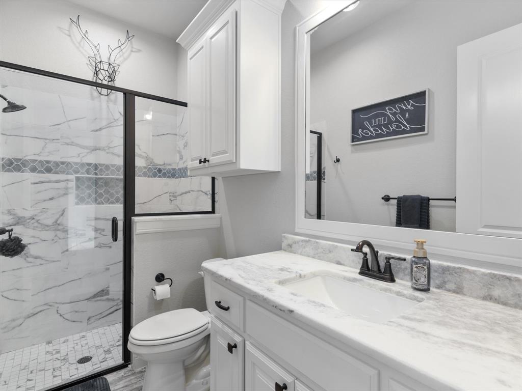 209 Rio Rancho Drive Decatur, TX 76234 - Photo 30 of 34 a bathroom with a granite countertop sink toilet and shower