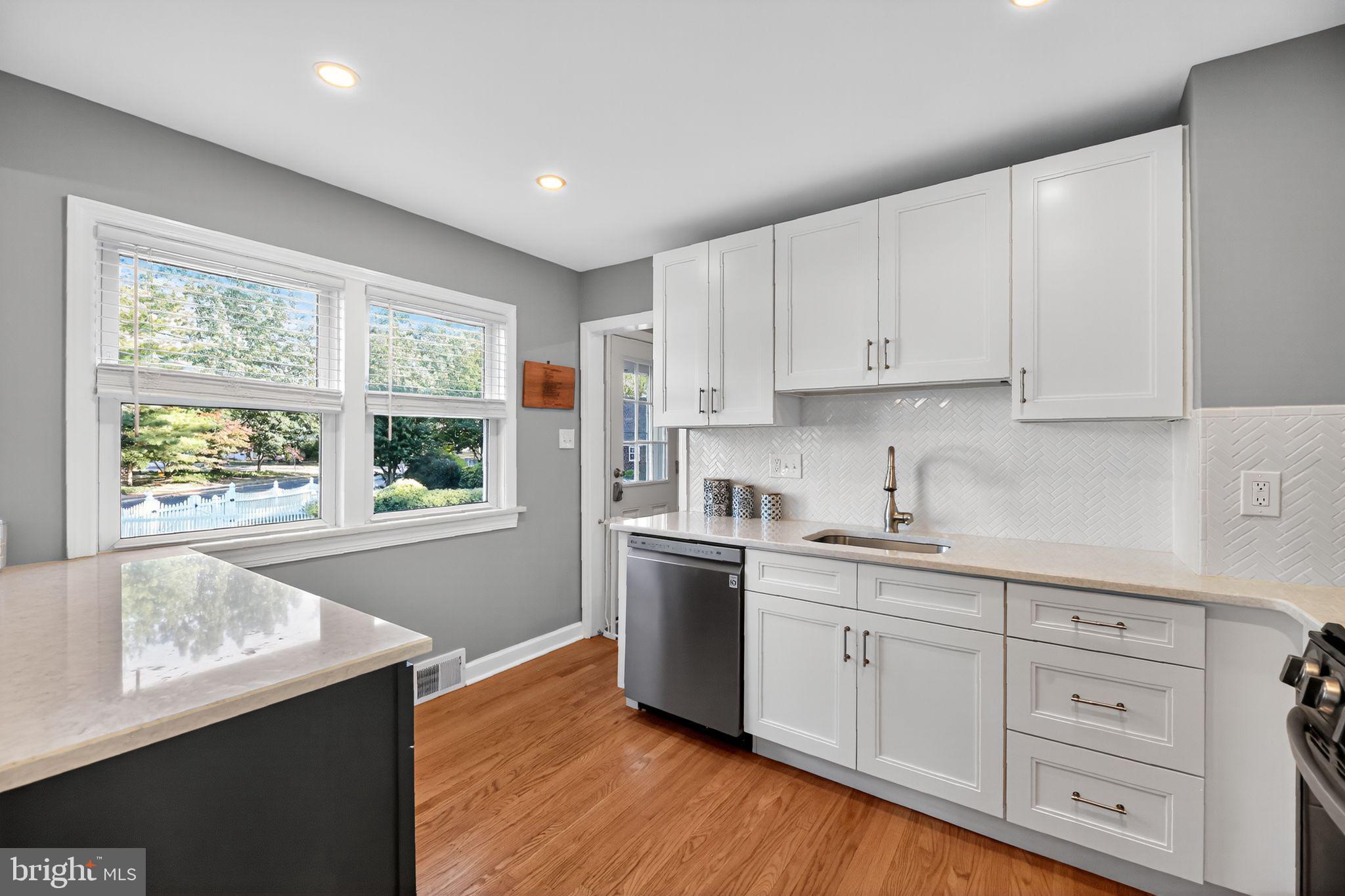 1201 Wayne Road Haddonfield, NJ 08033 - Photo 11 of 36 a kitchen with white cabinets and wooden floor