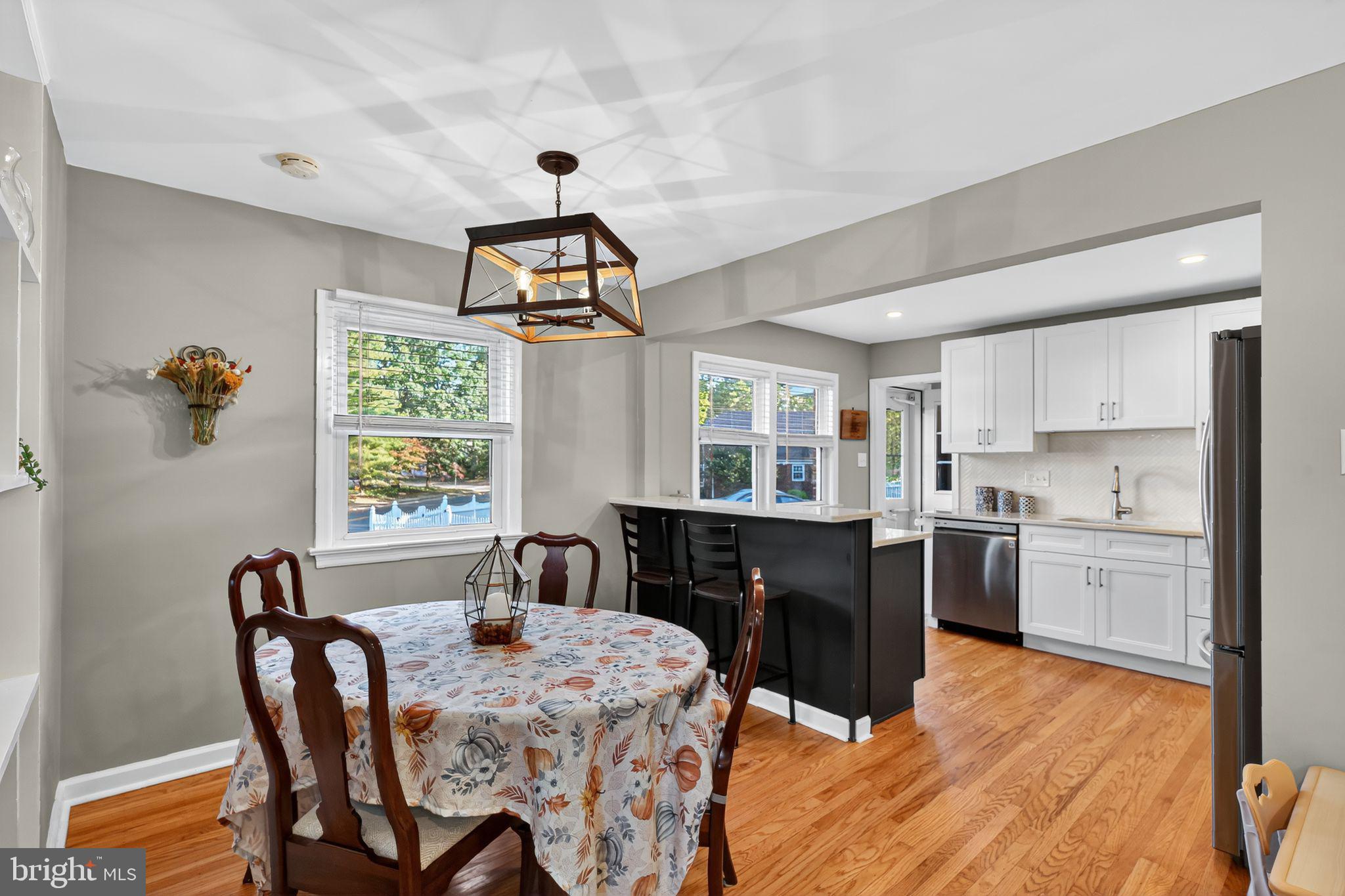 1201 Wayne Road Haddonfield, NJ 08033 - Photo 10 of 36 a kitchen with stainless steel appliances granite countertop a stove a sink dishwasher a dining table and chairs with wooden floor