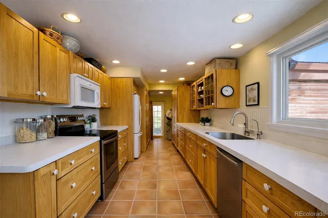 a large kitchen with stainless steel appliances granite countertop a sink and cabinets