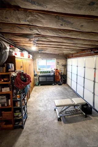 a garage with a car furniture and tools shelf