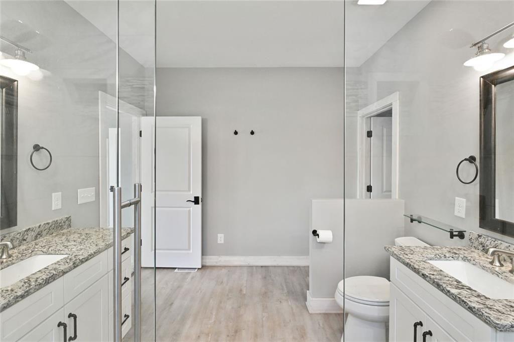 2040 Ridge Road Cumming, GA 30041 - Photo 23 of 52 a spacious bathroom with a granite countertop sink a toilet a mirror and shower
