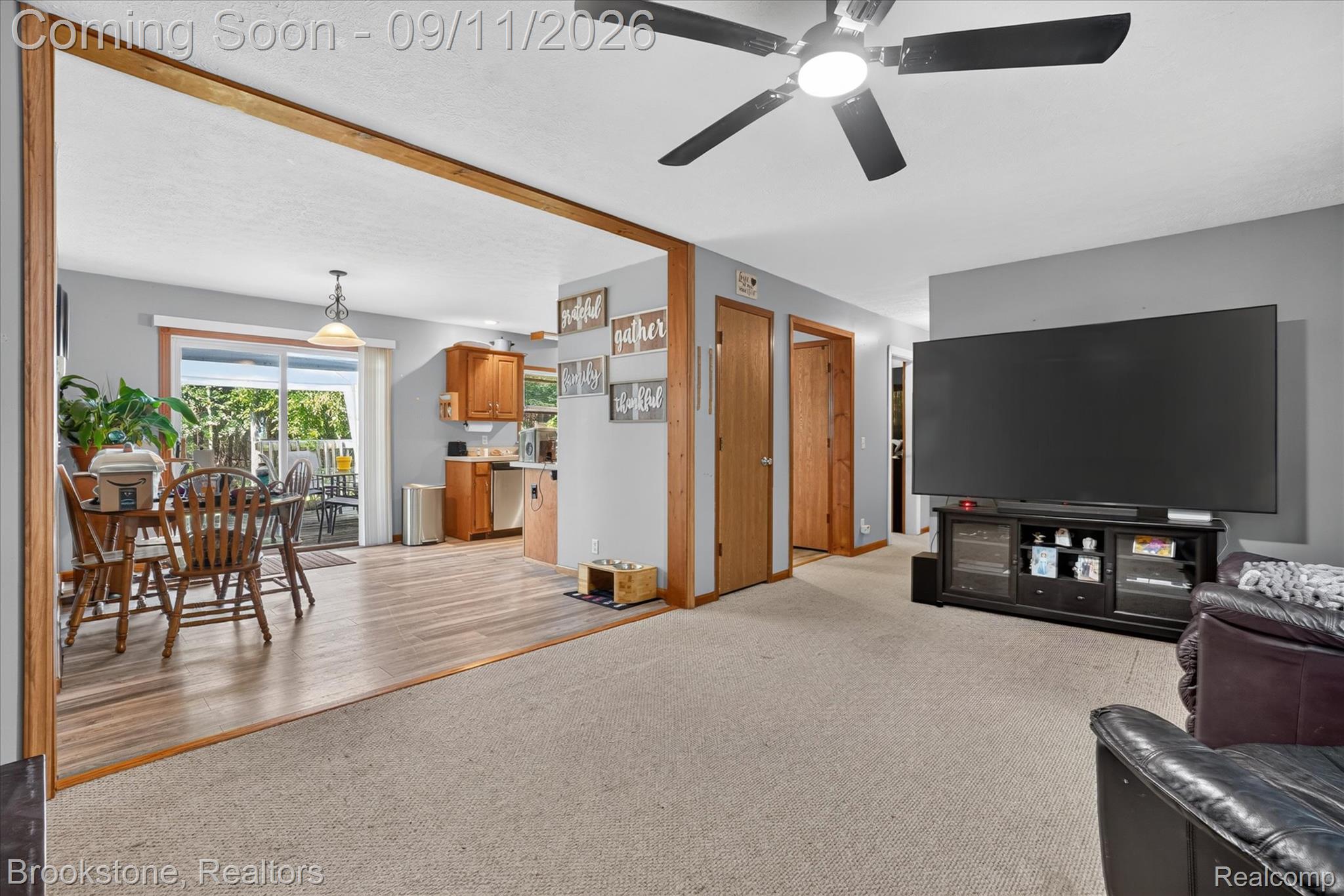 1812 South Steel Road Merrill, MI 48637 - Photo 7 of 39 Wood-finish flooring, sliding glass door, overhead lighting, wood trim, and a ceiling fan