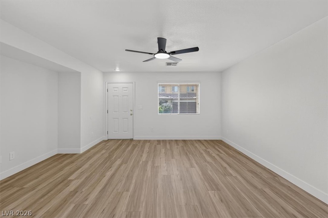 552 Albacate Street Henderson, NV 89015 - Photo 5 of 40 Well-lit living area featuring rich hardwood flooring and a stylish ceiling fan.