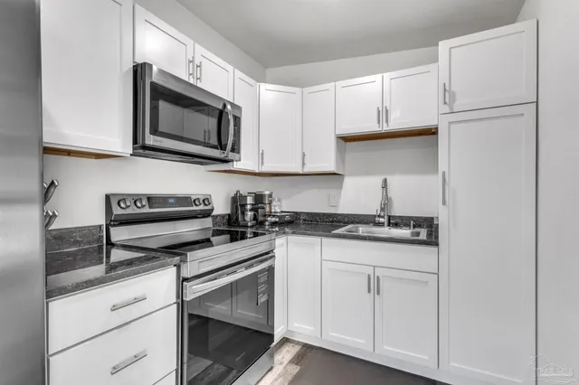 a kitchen with white cabinets and stainless steel appliances
