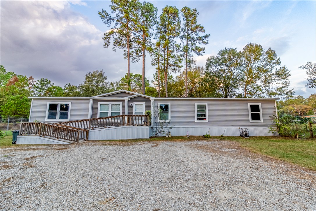 Manufactured / mobile home featuring a deck and view of scattered trees