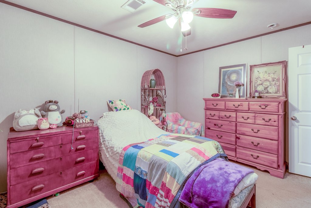 7715 Walnut Tree Lane Plantersville, TX 77363 - Photo 22 of 41 a bedroom with a bed and a dresser