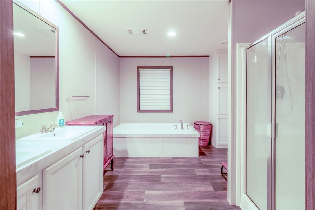 7715 Walnut Tree Lane Plantersville, TX 77363 - Photo 25 of 41 Full bath featuring vanity, a stall shower, dark wood-type flooring, a garden tub, and crown molding