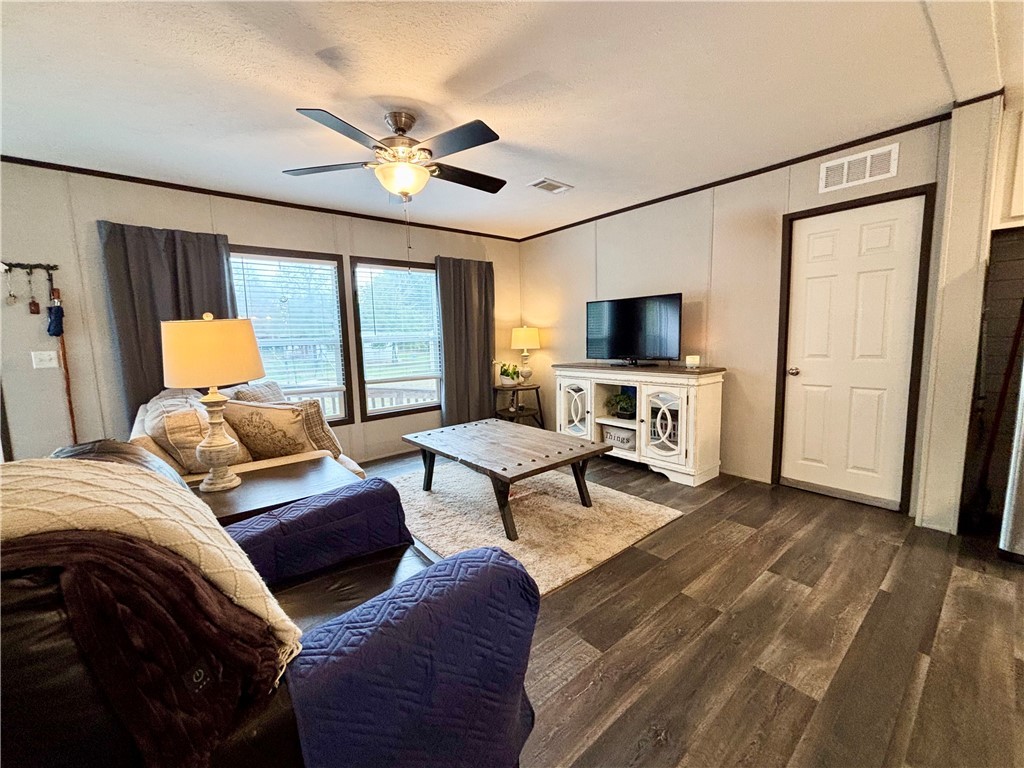 7715 Walnut Tree Lane Plantersville, TX 77363 - Photo 4 of 41 a bedroom with a bed a couch and a flat tv screen on dresser