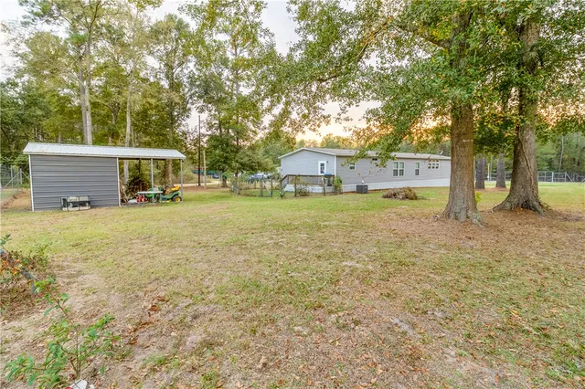 a view of a house with backyard and trees
