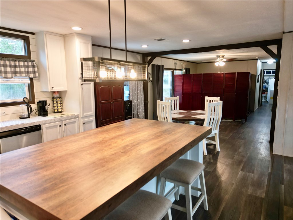 7715 Walnut Tree Lane Plantersville, TX 77363 - Photo 6 of 41 a kitchen with stainless steel appliances kitchen island granite countertop a table chairs in it and wooden floors