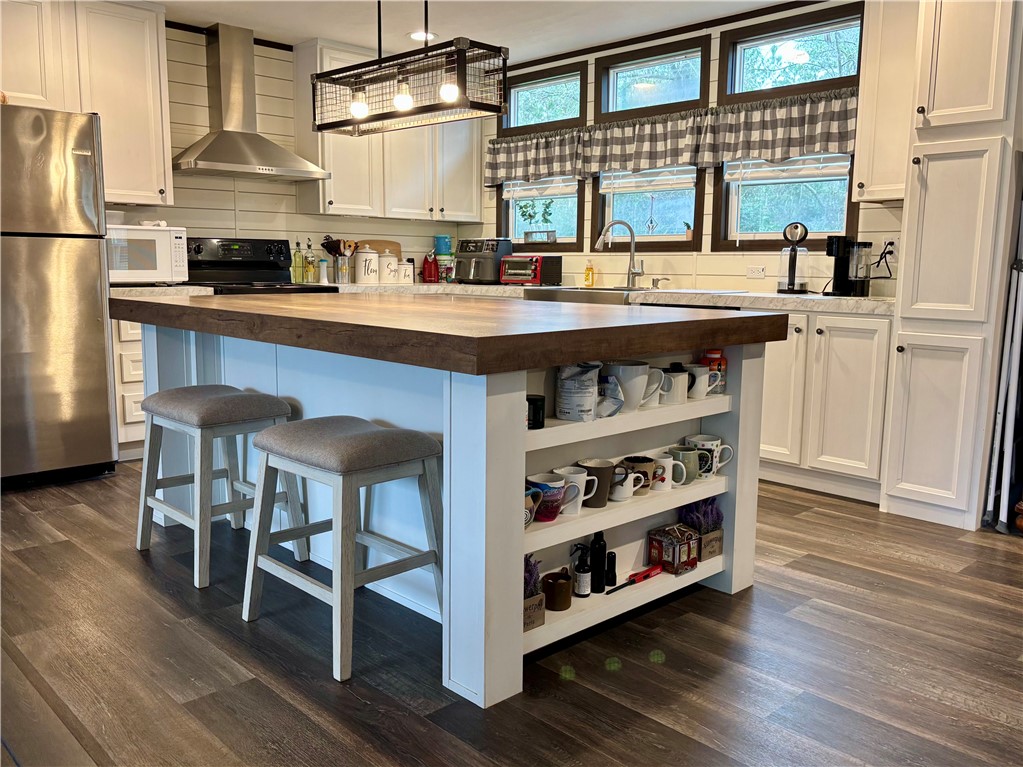 7715 Walnut Tree Lane Plantersville, TX 77363 - Photo 7 of 41 a kitchen with stainless steel appliances granite countertop a stove and a refrigerator