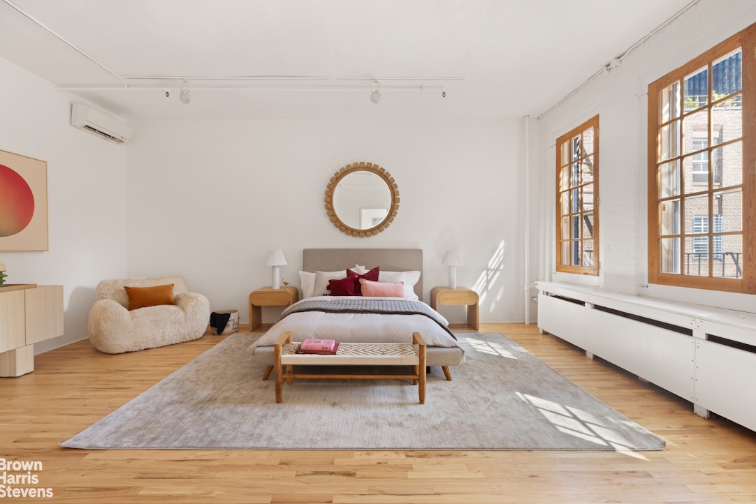 152 Wooster Street, Unit 5B Manhattan, NY 10012 - Photo 10 of 22 a bed room with a bed and wooden floor