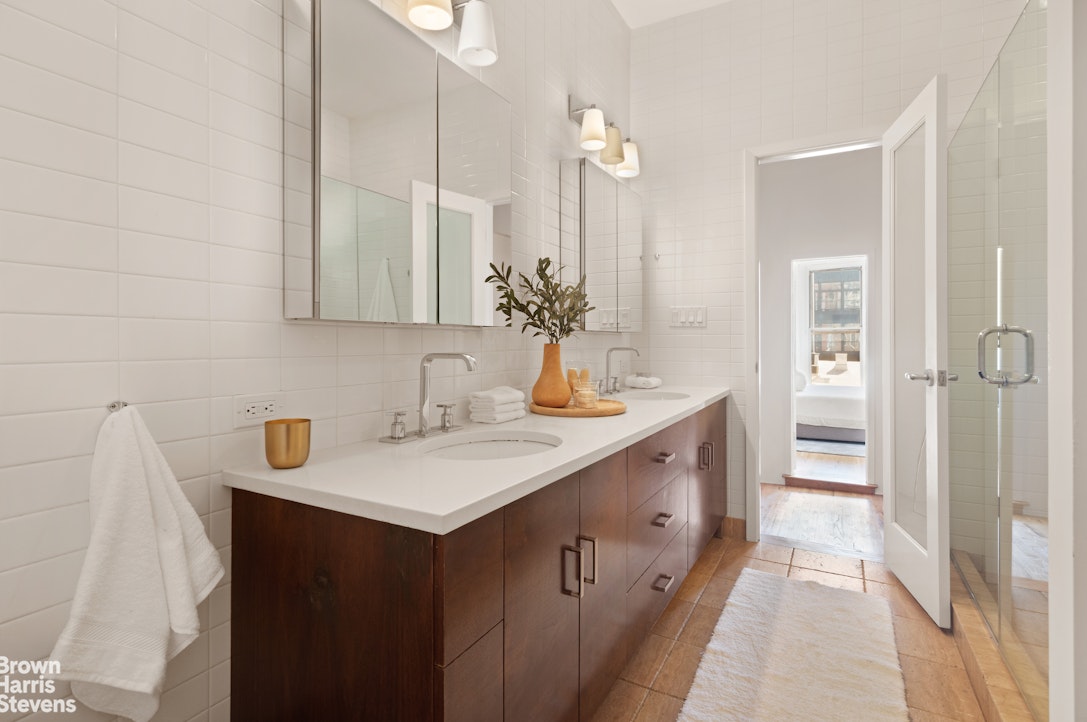 152 Wooster Street, Unit 5B Manhattan, NY 10012 - Photo 9 of 22 a spacious bathroom with a sink and a mirror