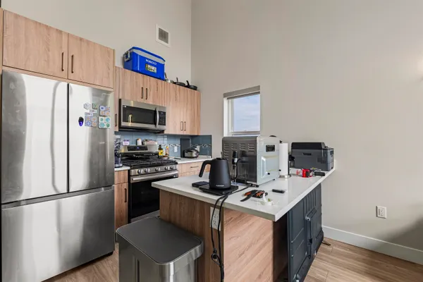 a kitchen with a refrigerator a stove top oven a sink and cabinets