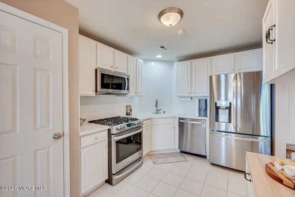a kitchen with stainless steel appliances granite countertop a stove a refrigerator and a microwave