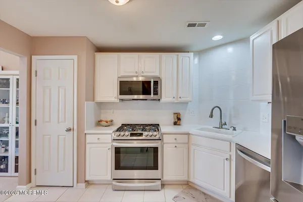 a kitchen with stainless steel appliances a stove microwave and sink