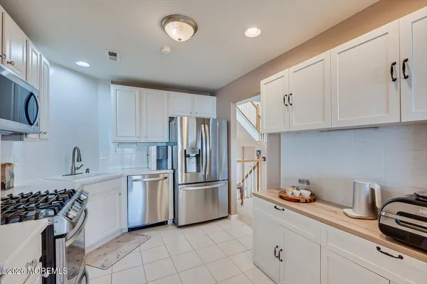 a kitchen with white cabinets and appliances