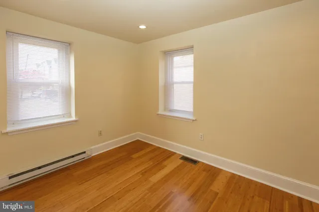 a view of a room with wooden floor and fan