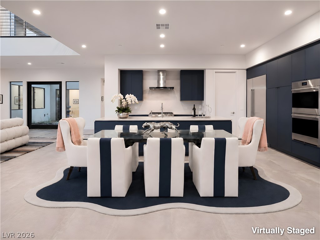 25 Falling Ridge Lane Henderson, NV 89011 - Photo 10 of 48 An open-concept living space integrates a stylish kitchen with sleek cabinetry and a contemporary dining area.